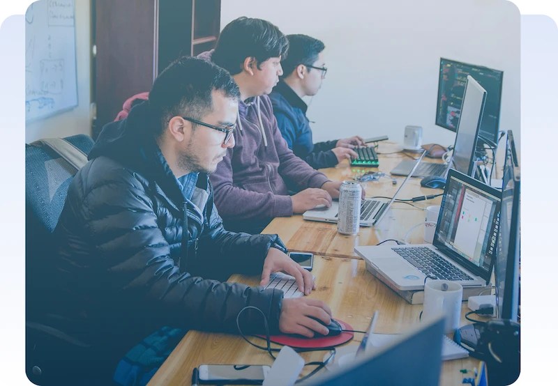 AI & Machine Learning Page Software developers working together at computers in a modern office.