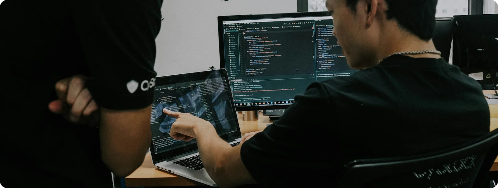 IT Bigger Size Software developers reviewing code on multiple screens.